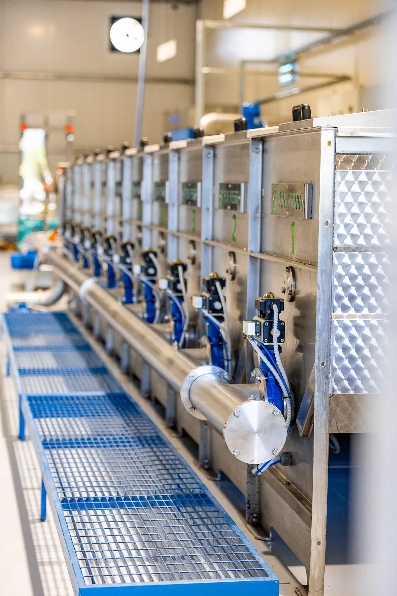 The milling line inside the hall at Xironomi — stainless units in a numbered row